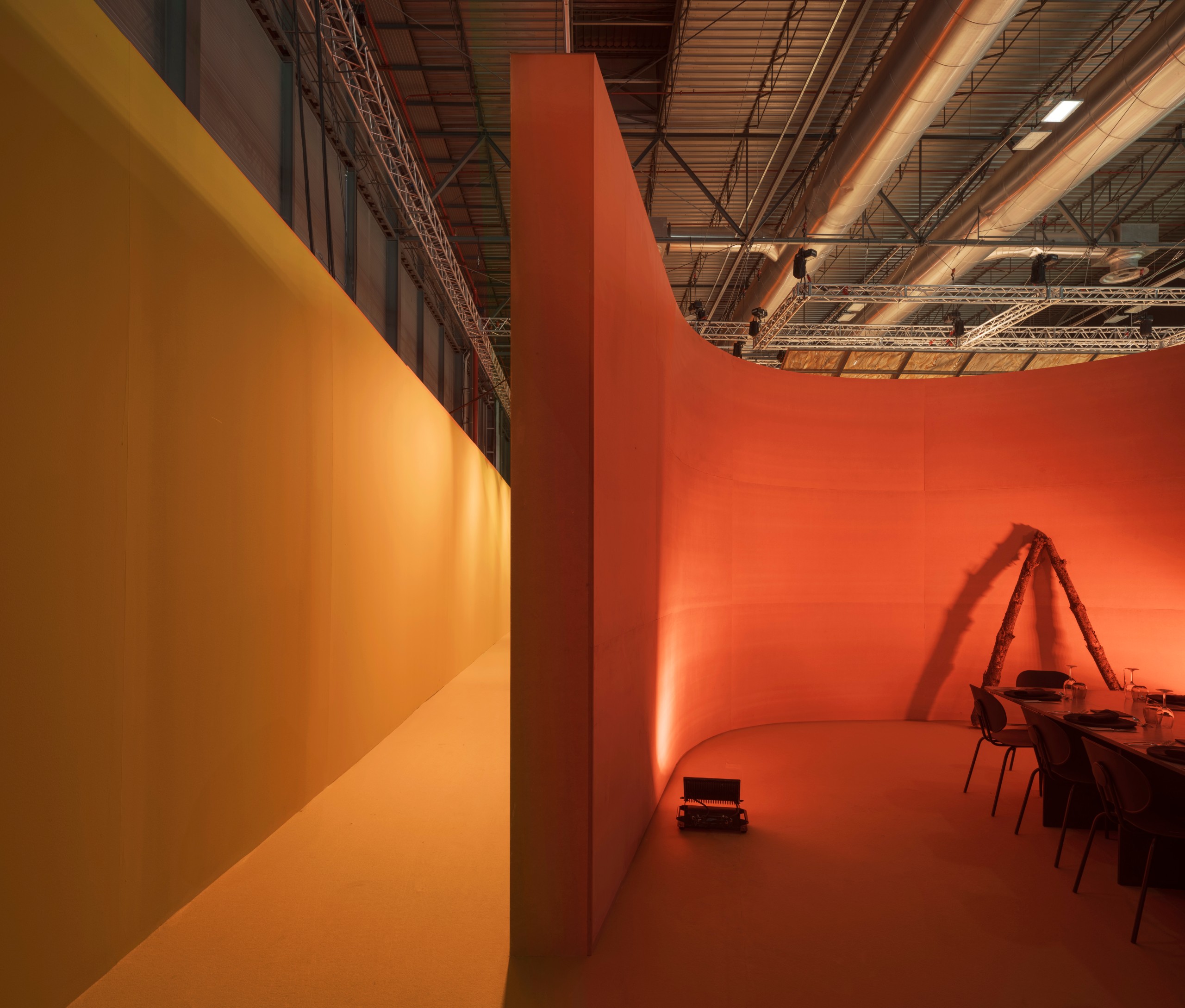 A curved red wall beside a yellow wall at the threshold of the restaurant