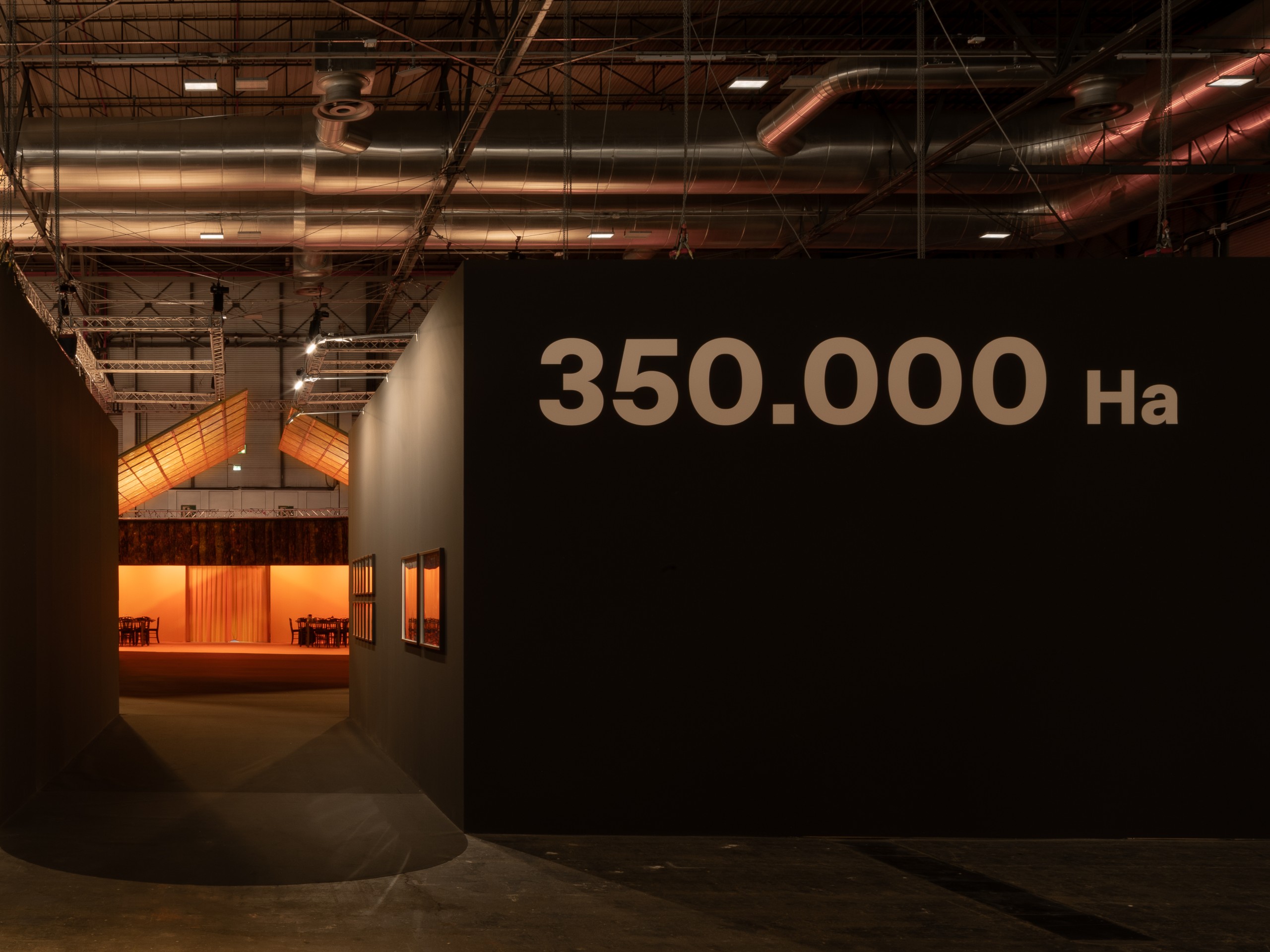 Dark entrance wall printed with the title 350.000 Ha