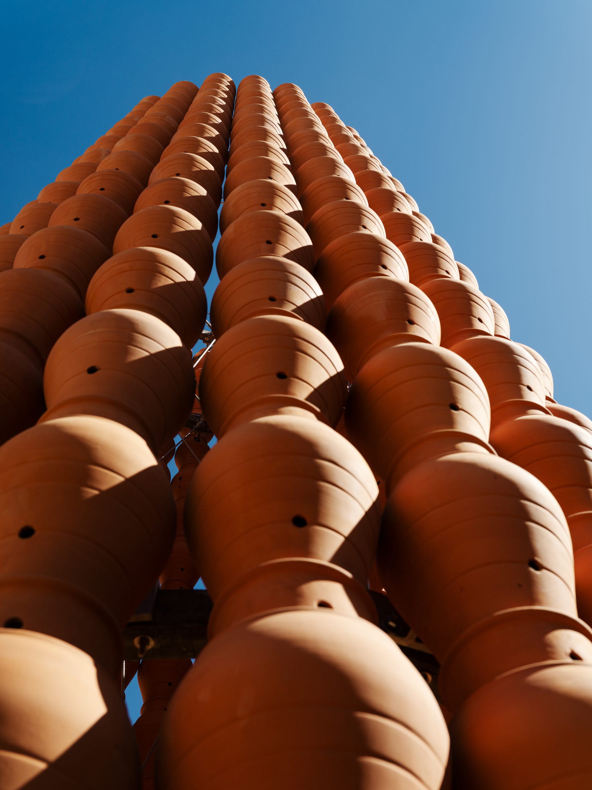 A close perspective emphasizes the tower’s layered construction from individual vessels.