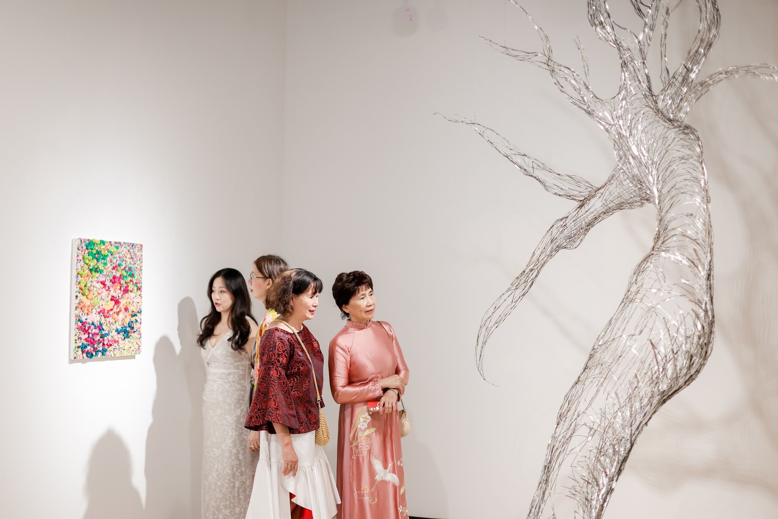 Visitors beside the steel branches of Enduring Vitality