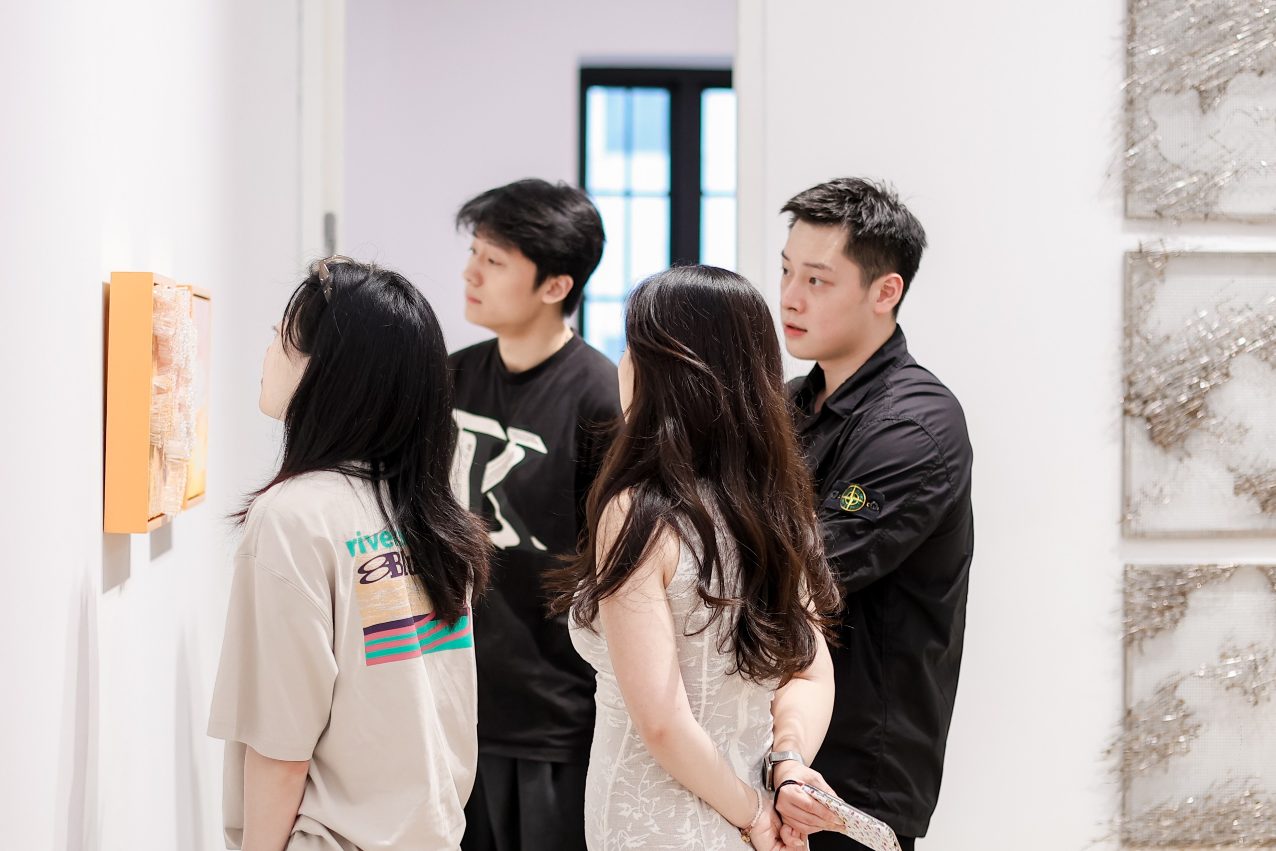 Visitors next to grey woven steel panels