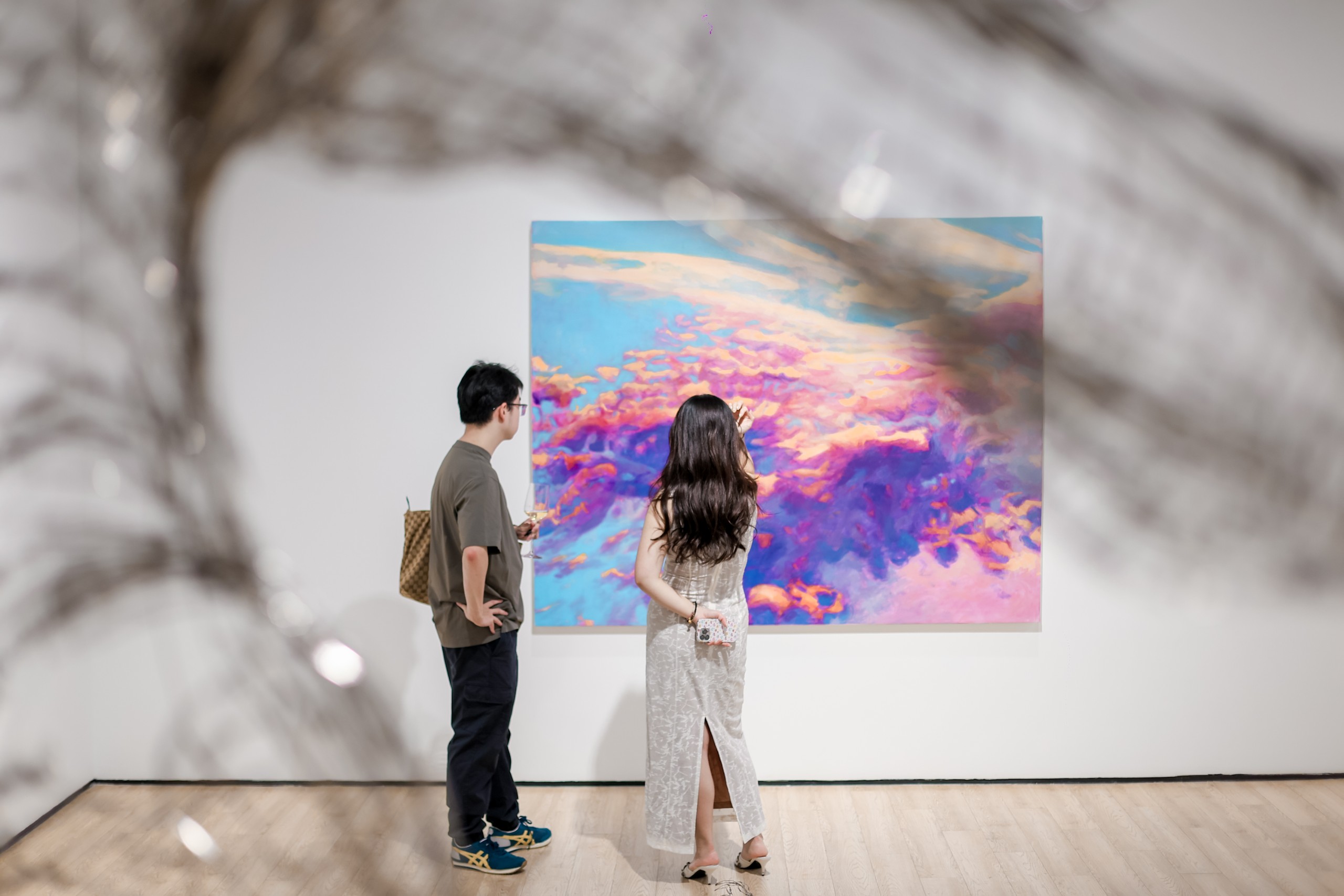 A cloud painting seen through a blurred steel branch