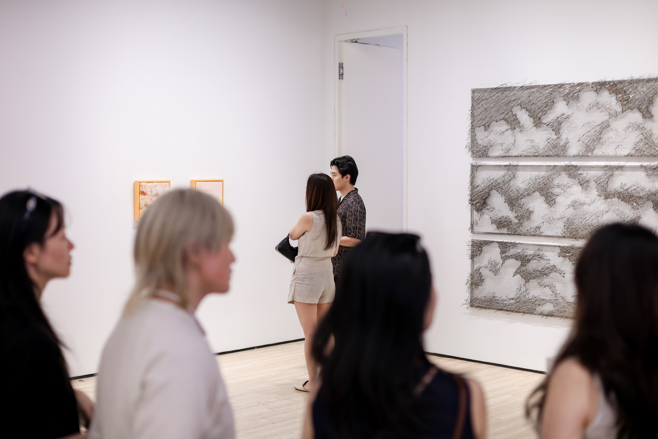 Three grey woven steel cloud panels on the gallery wall