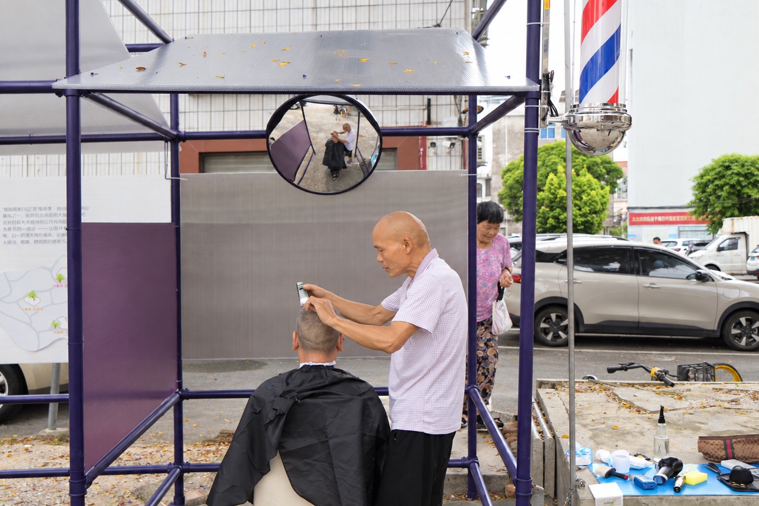 A traffic mirror serves as the barber’s mirror, beside a three-colour rotating light