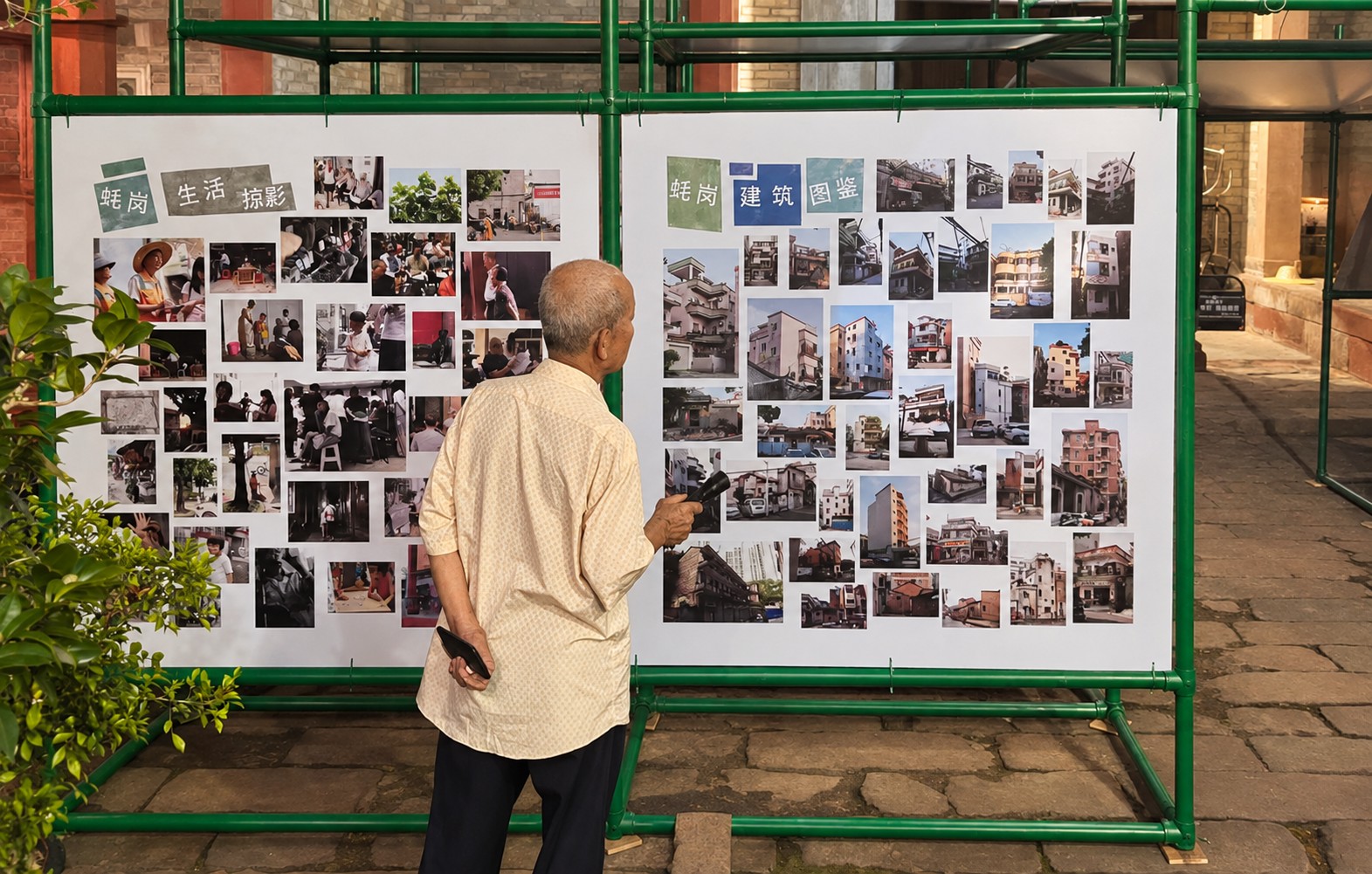 A villager pauses in front of a wall of photographs