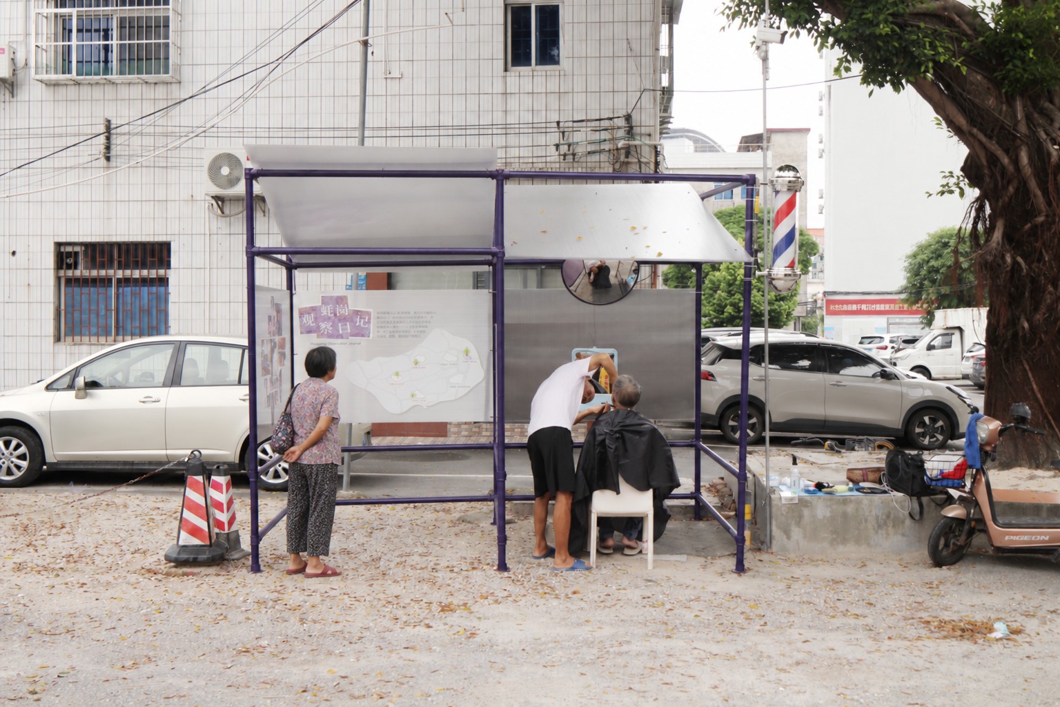 A woman stops to look at the exhibition beside the barber pavilion