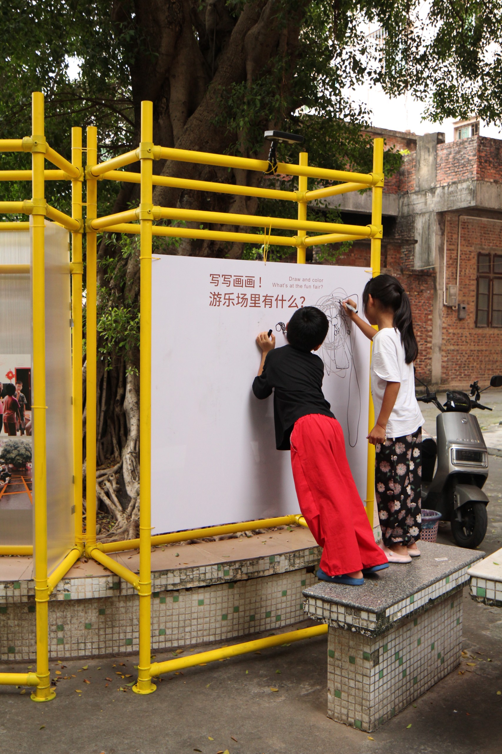 Children drawing on the whiteboard of the Graffiti Wall