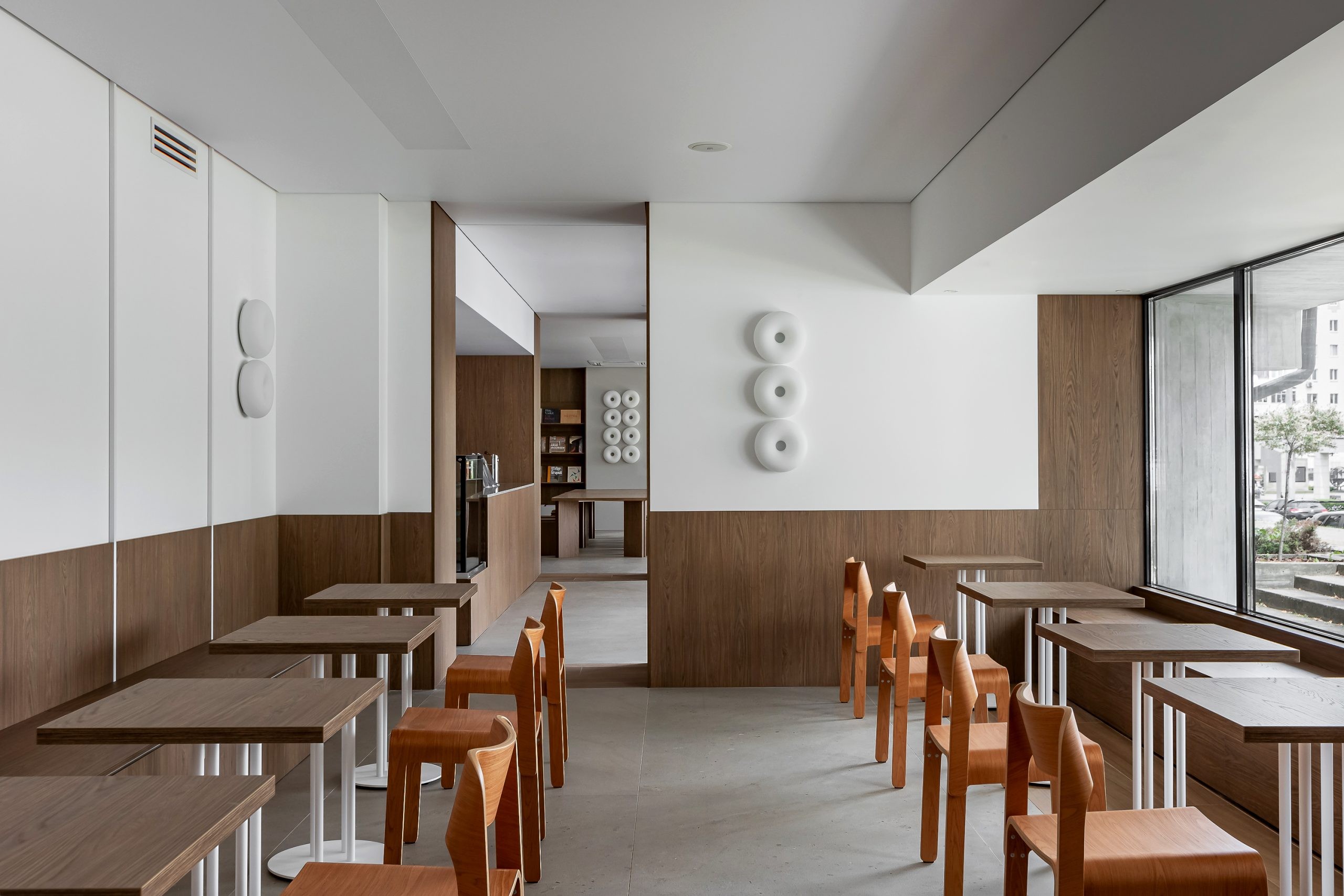 Warm timber surfaces organize the café and bookstore.