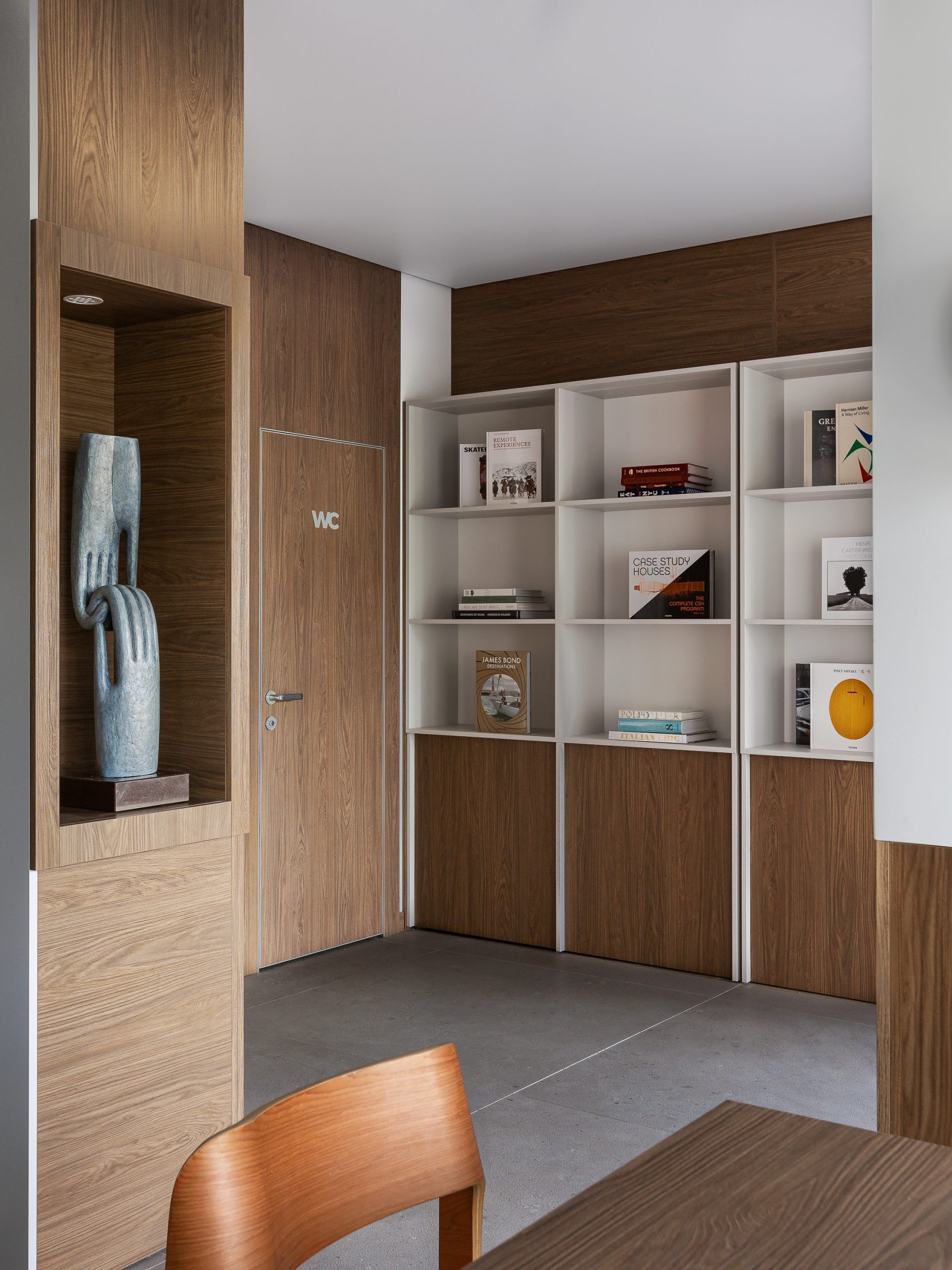 A restrained palette places emphasis on books, objects and the grain of the timber surfaces.