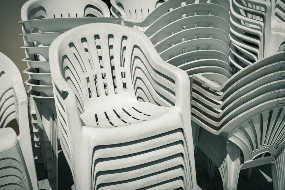 Stacked white monobloc chairs