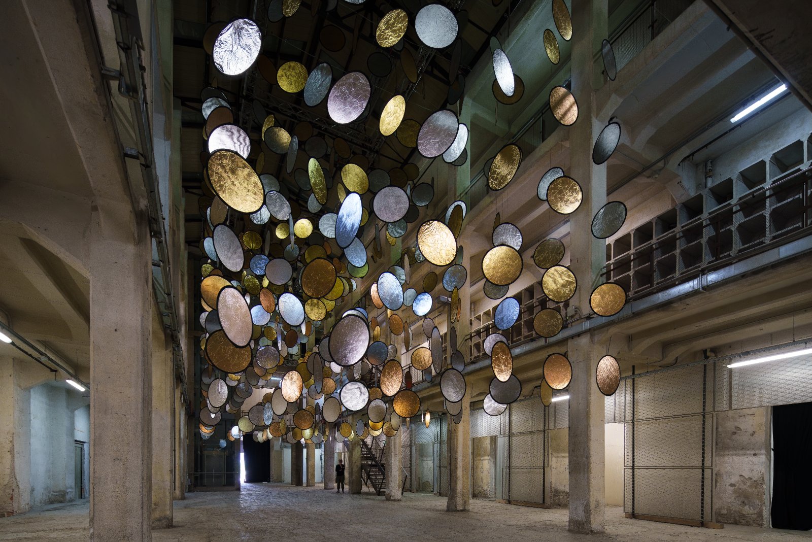 SpY, HALOS, gold and silver reflective circles suspended in a former railway factory in Florence