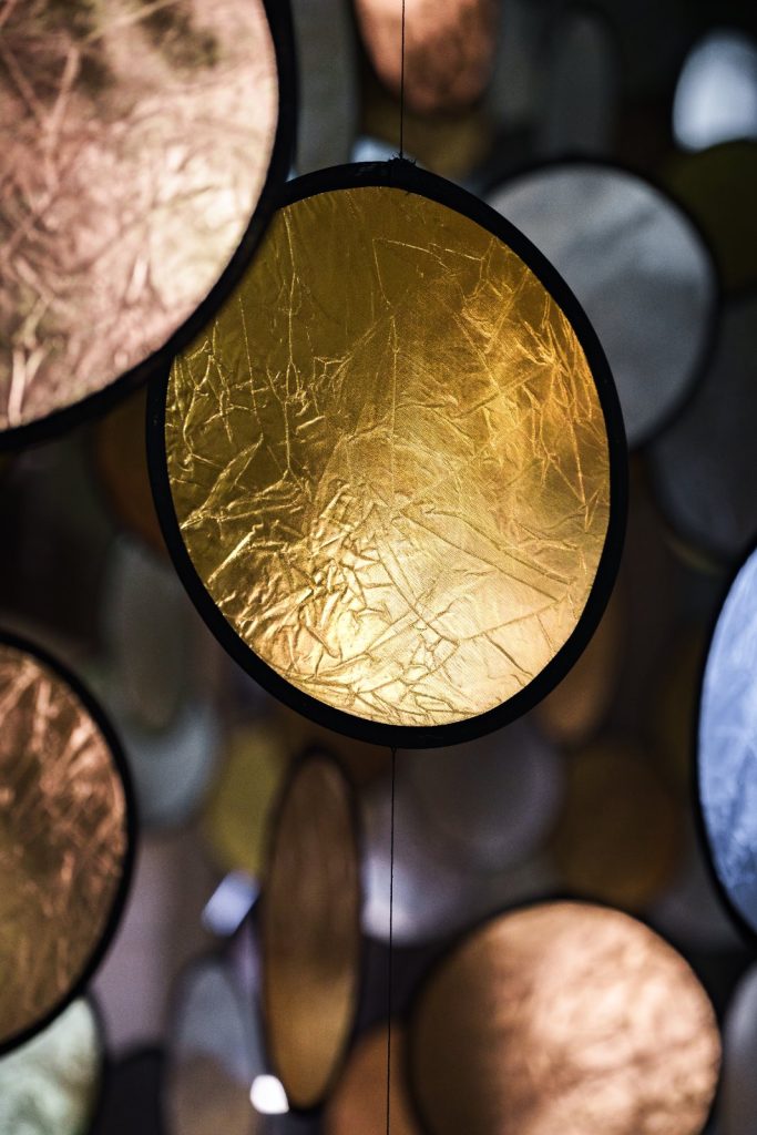 SpY, HALOS, gold and silver reflective circles suspended in a former railway factory in Florence
