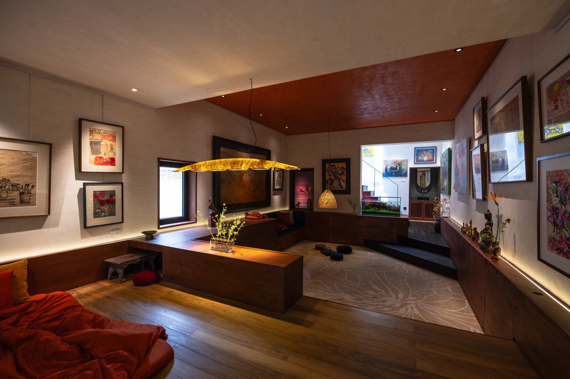 The Nest by Comma.Studio: the open lower floor, with paintings hung above low wall cabinets