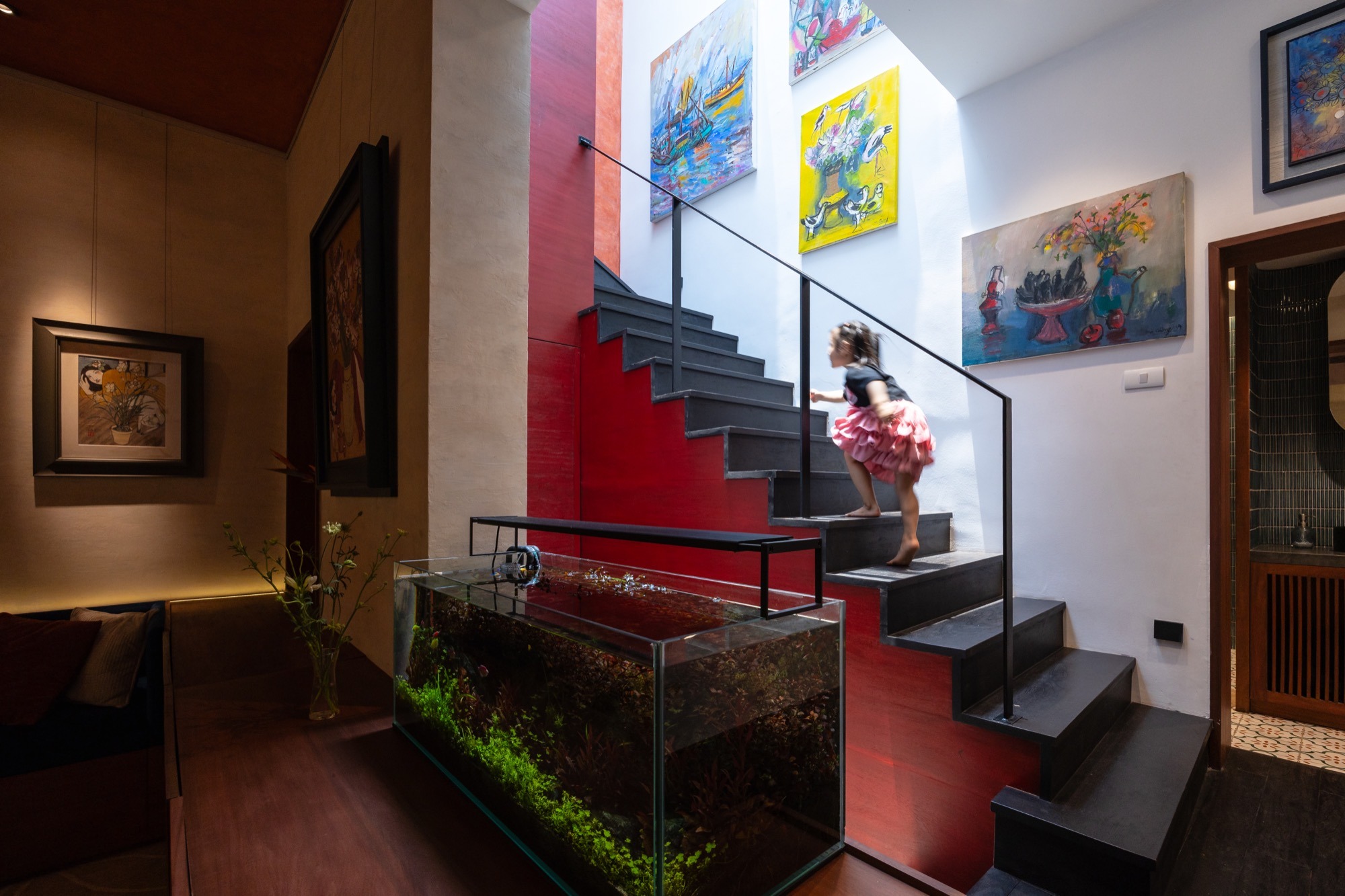 The black stair rising past a planted ledge